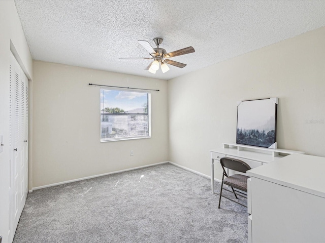 office featuring carpet flooring, ceiling fan, a textured ceiling, and baseboards