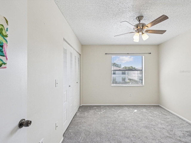 unfurnished bedroom featuring carpet, a closet, ceiling fan, a textured ceiling, and baseboards