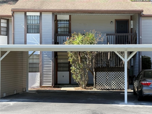 exterior space featuring covered porch and roof with shingles