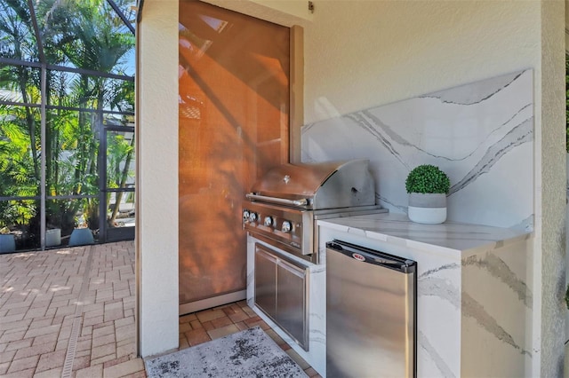 view of patio / terrace featuring an outdoor kitchen, grilling area, and a lanai