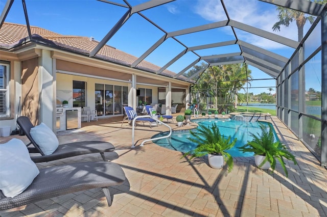 view of pool featuring a pool with connected hot tub, glass enclosure, and a patio