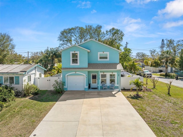 traditional-style home with stucco siding, concrete driveway, a front yard, a gate, and fence