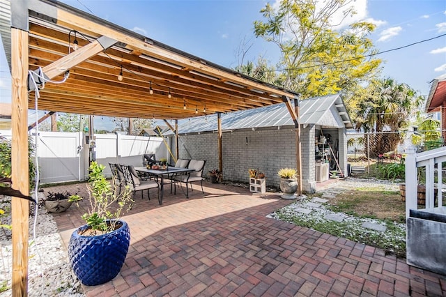 view of patio with outdoor dining area, fence, and a gate