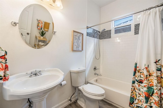 bathroom with shower / bath combination with curtain, toilet, a sink, wood finished floors, and baseboards