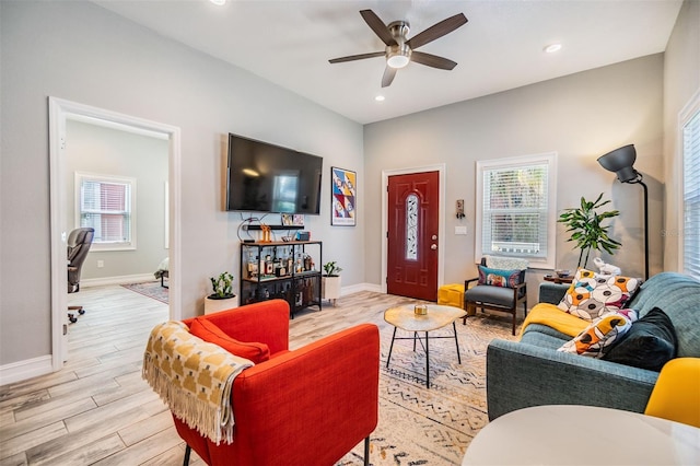 living room featuring baseboards, light wood-style floors, recessed lighting, and a healthy amount of sunlight