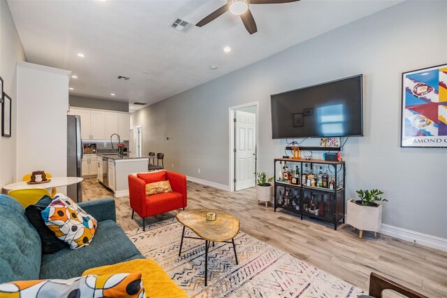 living area featuring light wood-style floors, baseboards, visible vents, and recessed lighting