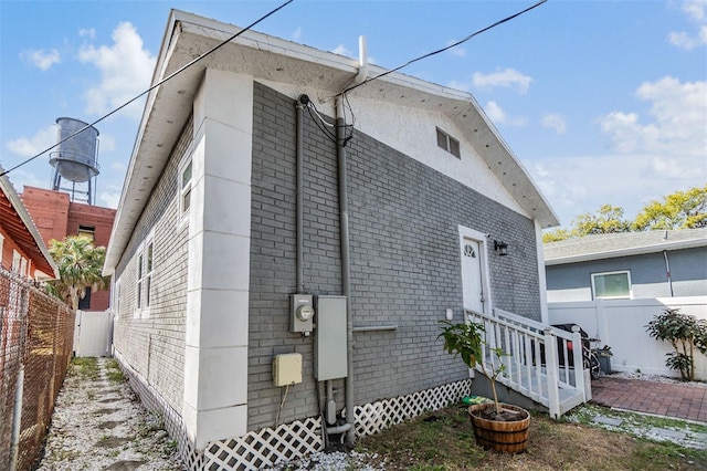 exterior space with brick siding and fence