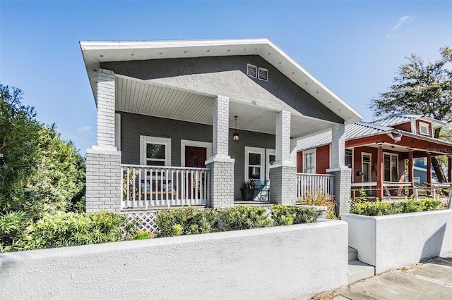 craftsman house with a porch and brick siding