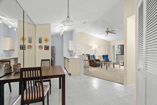 dining area featuring light carpet, visible vents, lofted ceiling, a textured ceiling, and light tile patterned flooring