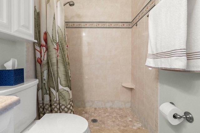 full bathroom featuring toilet and tiled shower