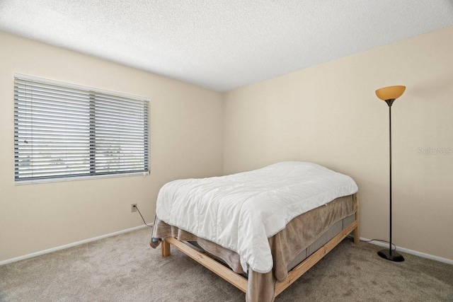 carpeted bedroom featuring a textured ceiling and baseboards