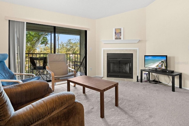 living area with carpet floors, a tiled fireplace, and baseboards