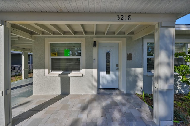 entrance to property featuring elevator and stucco siding