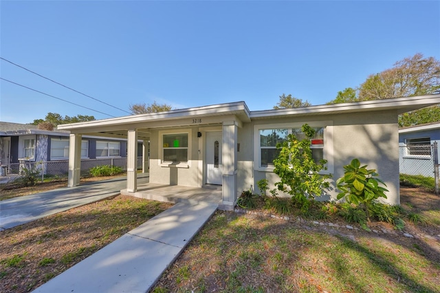 single story home featuring fence, a porch, and stucco siding