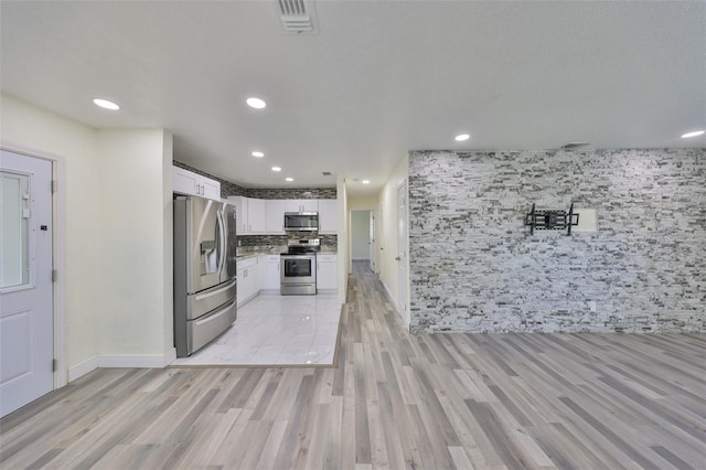 kitchen with stainless steel appliances, recessed lighting, white cabinets, and tasteful backsplash