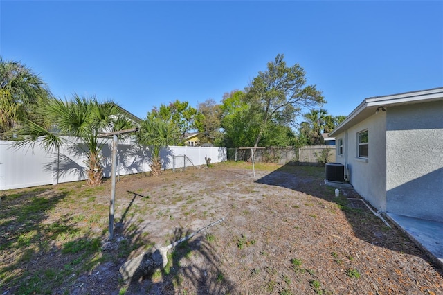 view of yard with a fenced backyard and central air condition unit