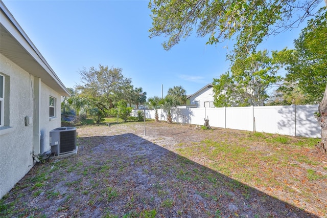 view of yard featuring a fenced backyard and central AC