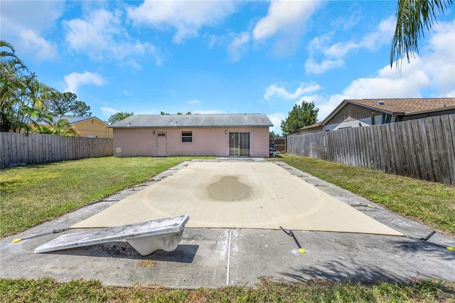 12704 128th Ln, Largo, FL 33774 - back of property featuring stucco siding, a yard, a patio, and a fenced backyard