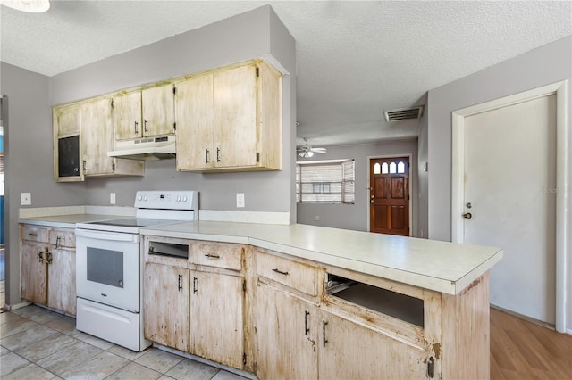 12704 128th Ln, Largo, FL 33774 - kitchen with visible vents, light countertops, under cabinet range hood, electric range, and a peninsula