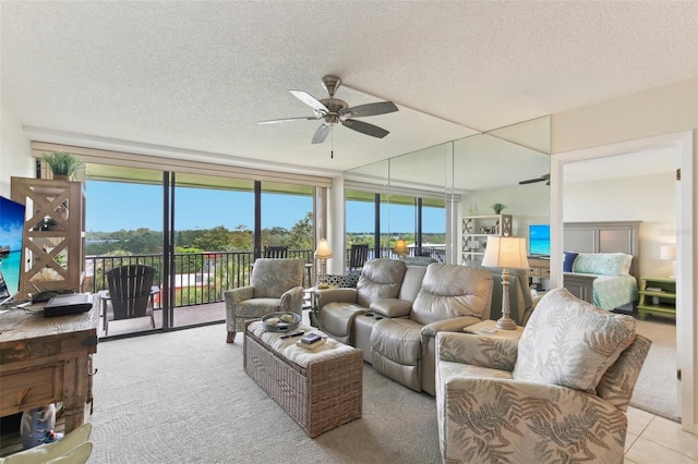 carpeted living room featuring a textured ceiling, plenty of natural light, and a ceiling fan