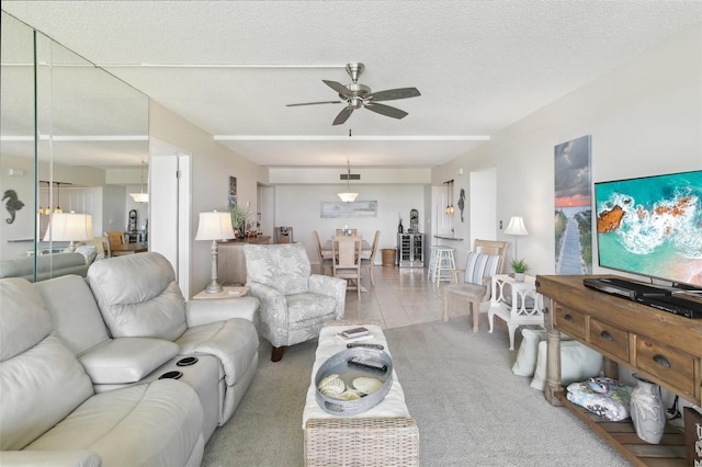 carpeted living room with a textured ceiling, ceiling fan, and tile patterned floors