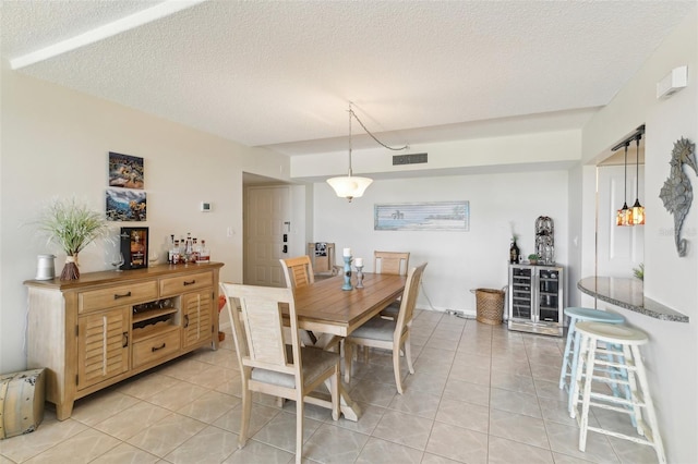 dining space with a textured ceiling and light tile patterned floors