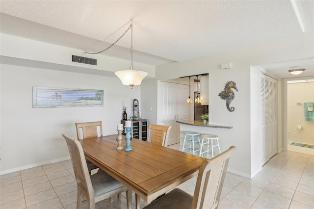 dining space with visible vents, a textured ceiling, baseboards, and light tile patterned floors