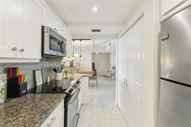 kitchen with light tile patterned floors, stainless steel appliances, visible vents, decorative backsplash, and white cabinetry