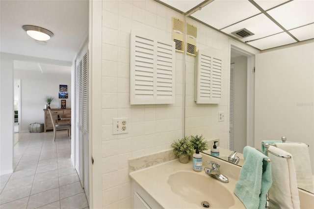 bathroom featuring visible vents, vanity, tile patterned flooring, and tile walls