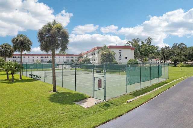 view of sport court featuring a yard and fence