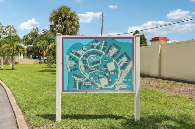 community / neighborhood sign featuring a yard and fence