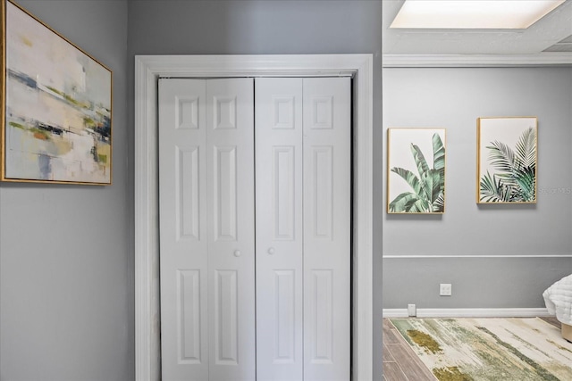 bedroom with baseboards, a closet, and wood finished floors