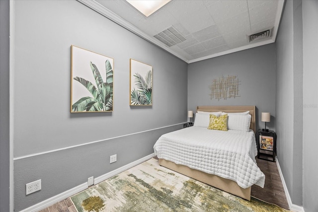 bedroom featuring baseboards, visible vents, and wood finished floors