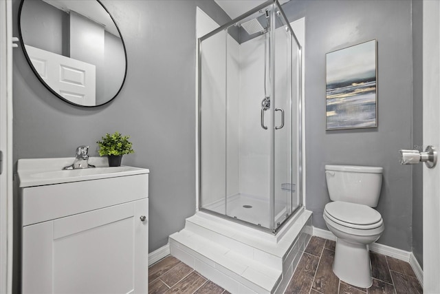 full bathroom with toilet, a stall shower, vanity, and wood finish floors