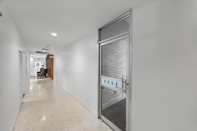 hall featuring recessed lighting, baseboards, and speckled floor