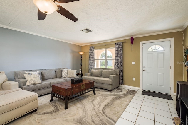 living room with light tile patterned floors, visible vents, ornamental molding, ceiling fan, and a textured ceiling