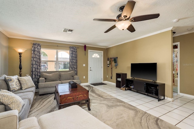 living area with a textured ceiling, ornamental molding, light tile patterned flooring, and visible vents