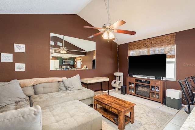 living area with a ceiling fan, tile patterned flooring, and lofted ceiling