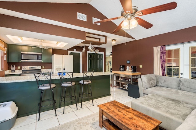 kitchen with light tile patterned floors, visible vents, a ceiling fan, lofted ceiling, and stainless steel appliances