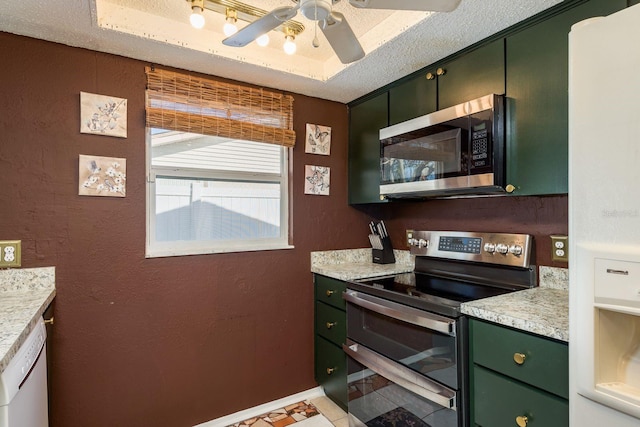 kitchen featuring a textured ceiling, stainless steel appliances, green cabinetry, and light countertops