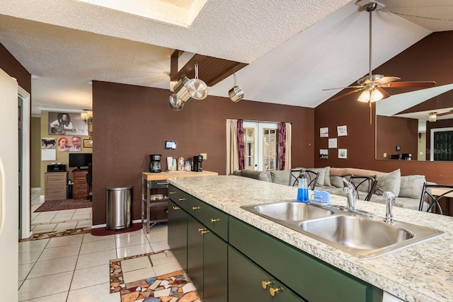 kitchen featuring light countertops, light tile patterned flooring, a sink, a textured ceiling, and green cabinetry