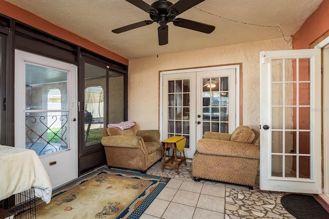 sunroom / solarium with a ceiling fan and french doors