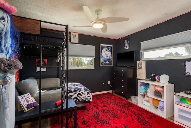 bedroom featuring a ceiling fan, a textured ceiling, and baseboards