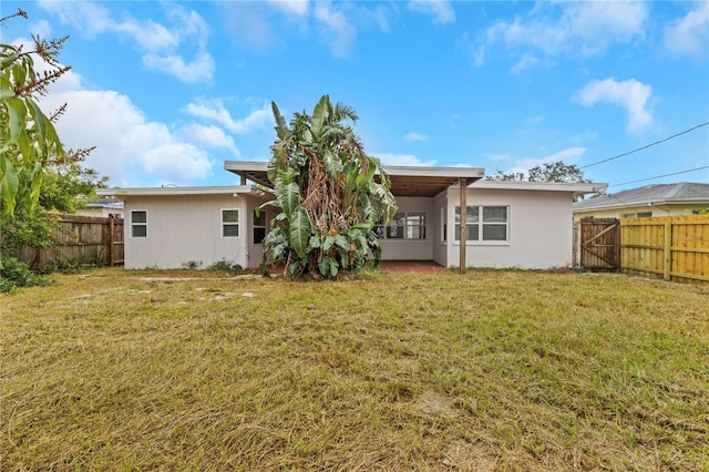 5813 18th Ave S, Gulfport, FL 33707 - back of house featuring a lawn and a fenced backyard