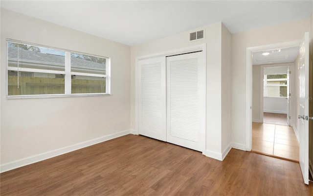 5813 18th Ave S, Gulfport, FL 33707 - unfurnished bedroom with a closet, visible vents, baseboards, and wood finished floors