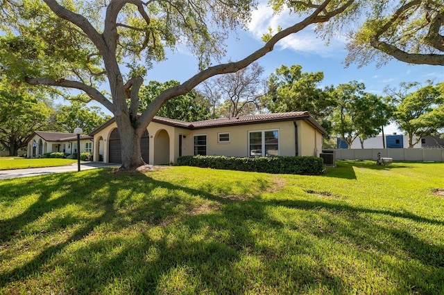 view of front facade featuring a garage, concrete driveway, fence, a front lawn, and stucco siding