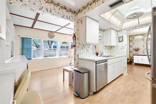 kitchen with white cabinets, appliances with stainless steel finishes, visible vents, and wallpapered walls