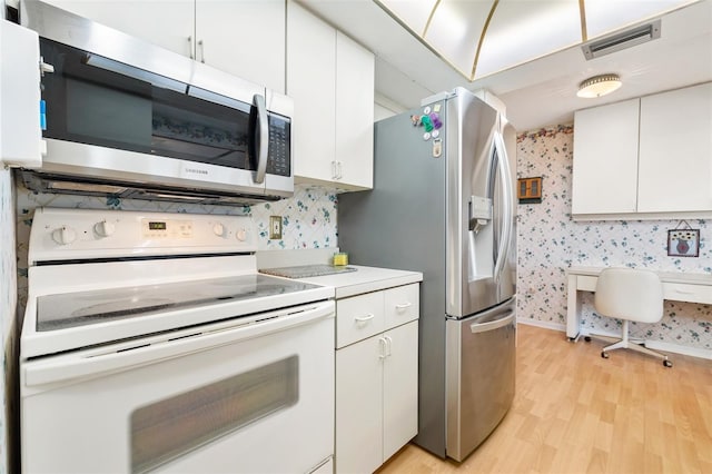 kitchen with wallpapered walls, visible vents, stainless steel appliances, and light wood-style floors