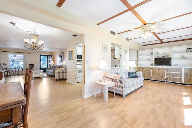 living area featuring baseboards, visible vents, light wood finished floors, and ceiling fan with notable chandelier