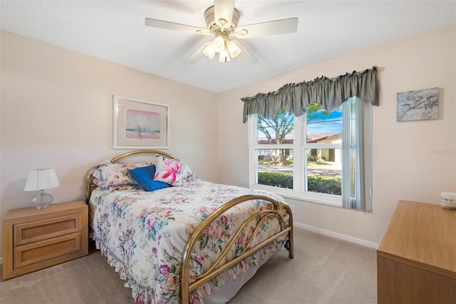 bedroom featuring a ceiling fan, carpet flooring, a textured ceiling, and baseboards